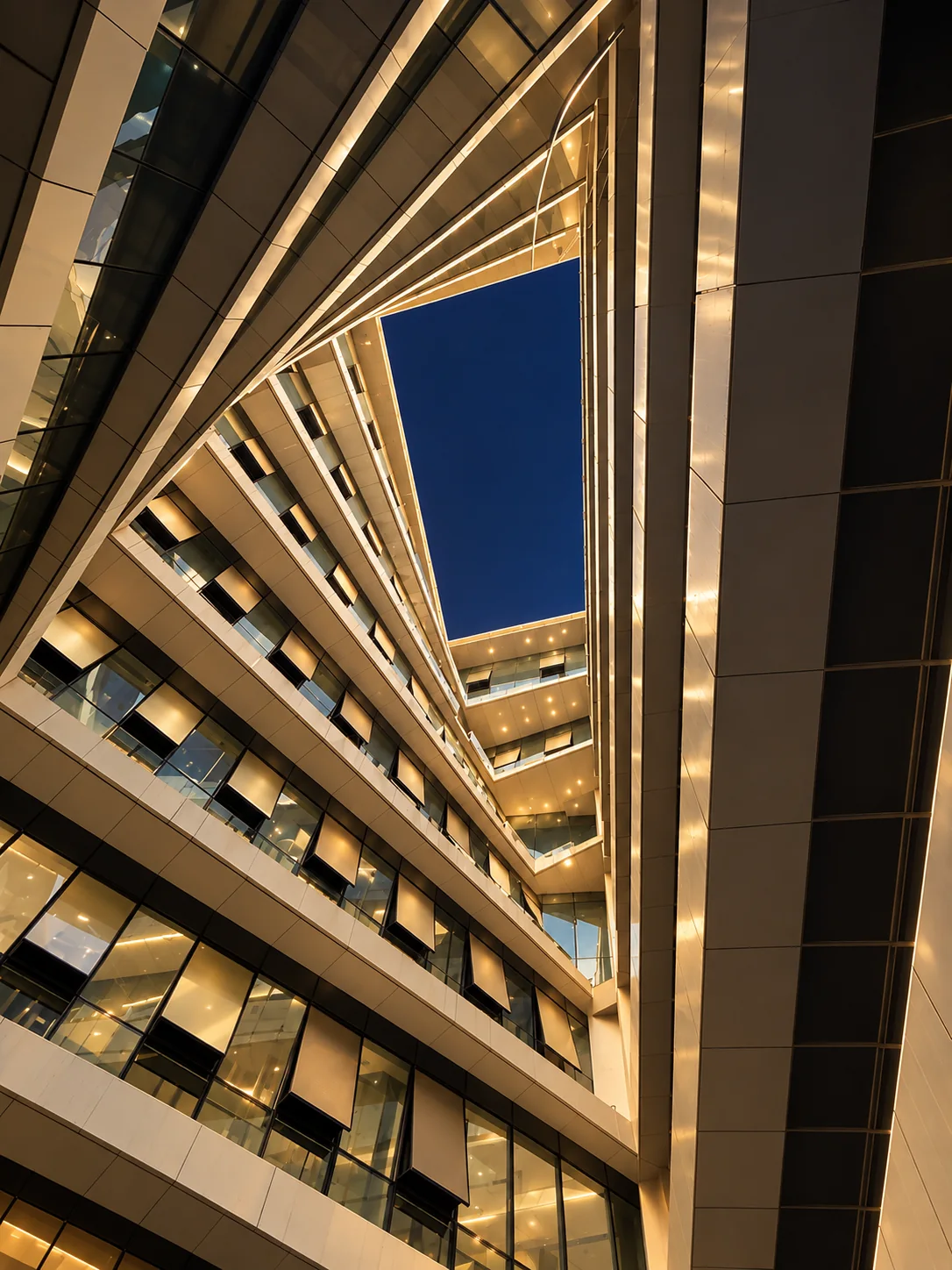 iTower atrium rising toward a deep blue night sky with warm architectural lighting