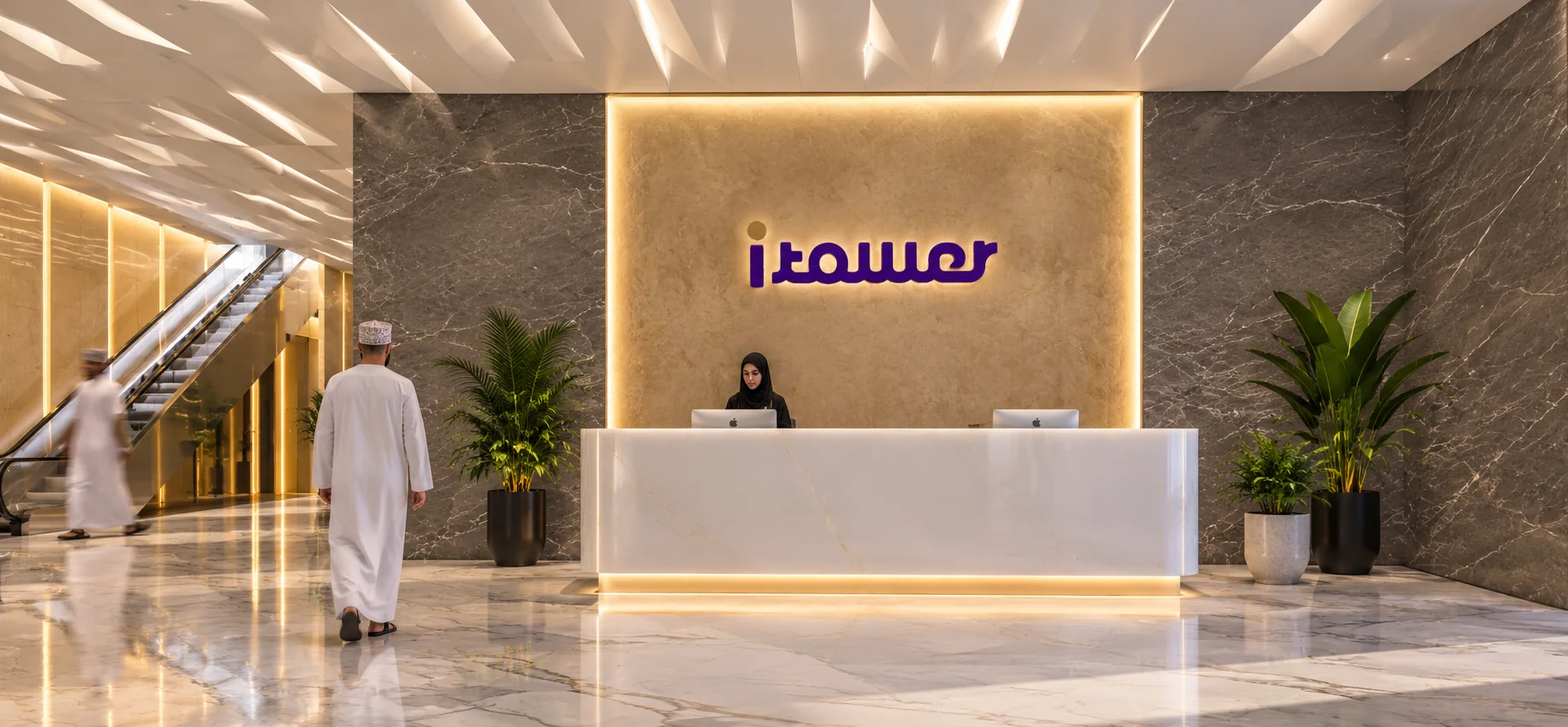 iTower reception with an illuminated logo wall, marble desk, warm lighting and escalators